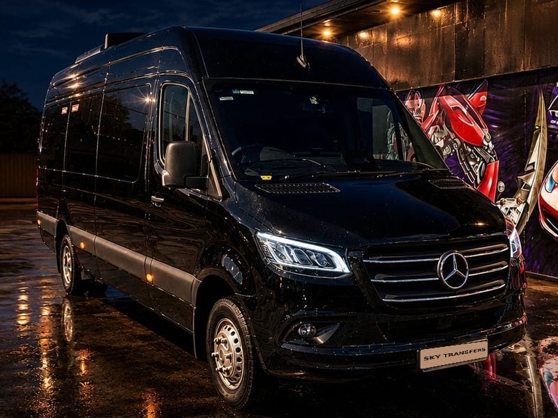 Our Mercedes Sprinter 18-seater, photographed at dusk.